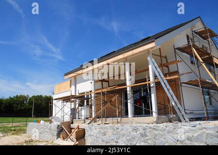 Ristrutturare e riparare la facciata della casa residenziale con isolamento in lana minerale, intonacatura, parete di pittura all'aperto. Ristrutturazione della costruzione della casa con Foto Stock