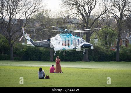 Visto da Ruskin Park a Lambeth sud di Londra, l'elicottero Agusta-Westland AW-169 (G-KSSC) del Kent Air Ambulance si alza di fronte alle case e alle famiglie vicino al Kings College Hospital a Camberwell durante il fine settimana delle festività della Banca di Pasqua, il 15th aprile 2022, a Londra, Inghilterra. Foto Stock