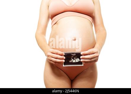 La donna incinta tiene in mano un'immagine ecografica Foto Stock