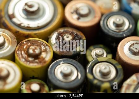 Primo piano della batteria usata con tracce di ruggine e corrosione. Concetto di rifiuti pericolosi elettronici Foto Stock