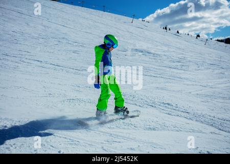 Ragazzo su snowboard in completo snowboarder vestito andare veloce in discesa Foto Stock