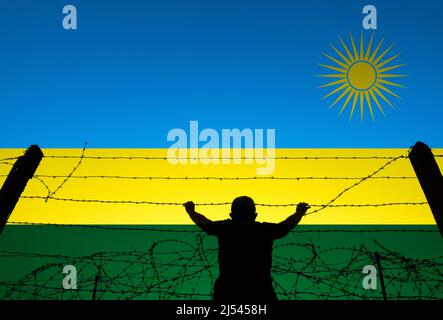 Uomo dietro filo spinato e bandiera del Ruanda. UK offshore trattamento dell'asilo, reinsediamento, rifugiati, immigrazione... concetto Foto Stock