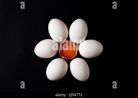 Uova bianche a forma di fiore su sfondo nero Foto Stock