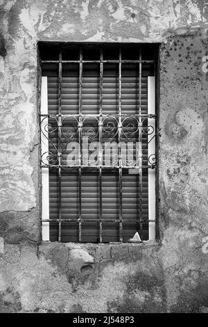 Finestra con traliccio in metallo forgiato con dettagli curvi e cieca in legno Foto Stock