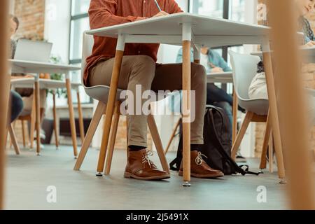 Studenti universitari che studiano in aula mentre scrivono Foto Stock