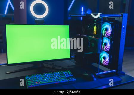 Monitor per computer desktop con schermo verde mockup nel bar dei videogamer. Attrezzatura professionale di alto livello. Foto di alta qualità Foto Stock