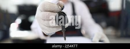 Il dipendente dell'assistenza auto tiene le chiavi in mano e gli appunti Foto Stock