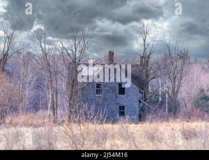 Un casale dall'aspetto spaoky abbandonato si trova tranquillamente in un prato di campagna nella zona rurale di Ottawa, Canada Foto Stock