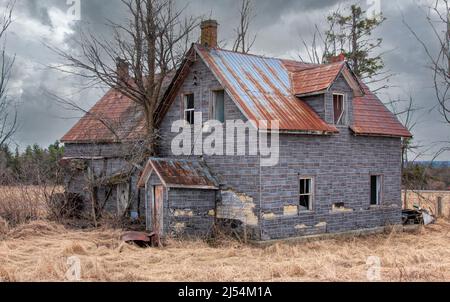 Un casale dall'aspetto spaoky abbandonato si trova tranquillamente in un prato di campagna nella zona rurale di Ottawa, Canada Foto Stock