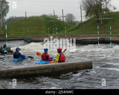 Bambini della scuola che affrontano l'acqua bianca di Holme Pierrepont Country Park Nottingham Inghilterra Regno Unito che si addita contro l'attuale National Water Sports Centre Foto Stock