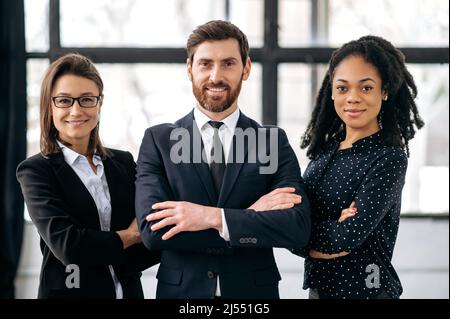 Successo multirazziale influente business team, la gente guarda la fotocamera, sorridendo. Colleghi creativi eleganti si trovano in un ufficio moderno, mostrano fiducia e successo, lavoro di squadra, concetto di collaborazione Foto Stock