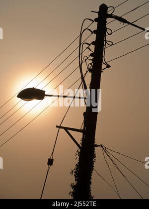 Qui vediamo palo che porta una luce di strada e cavi assortiti sulla mia passeggiata attraverso Lower Radley fino al Tamigi; è tutto illuminato da una sorgente luminosa Foto Stock