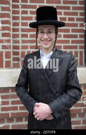 Ritratto di un allegro teen ebreo ortodosso fuori da una sinagoga a Williamsburg, Brooklyn, New York City. Foto Stock