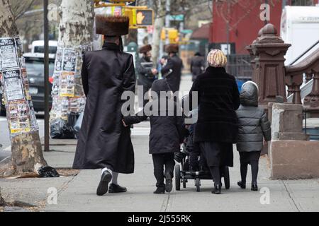 A Passover, una famiglia ebrea ortodossa non identificata che indossa abiti per le vacanze viene fotografata da dietro. Su Bedford Avenue a Williamsburg, Brooklyn. Foto Stock