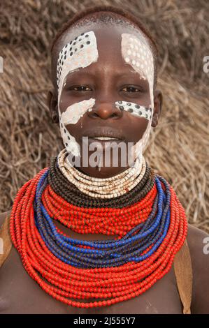 Giovani Karo donna con un sacco di colorati collane, labbro piercing e pitture facciali, Omo river valley, sud Etiopia Foto Stock