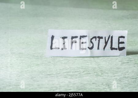 Lifestyle, parola scritta su un foglio che è in un posto verde chiaro. Foto Stock