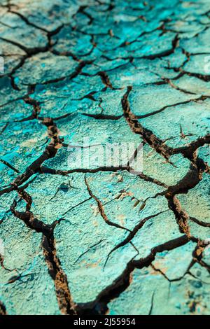 Liquido chimico blu essiccato su terreno secco incrinato, danni ambientali e inquinamento, fuoco selettivo Foto Stock