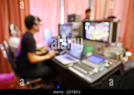 Blur persone che lavorano al commutatore di trasmissione esterno per lo streaming live, produzione elettronica sul campo Foto Stock