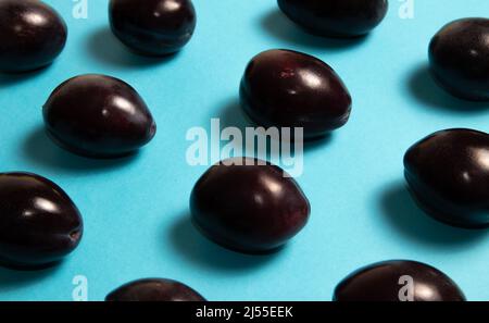 Prugne fresche su sfondo blu Foto Stock