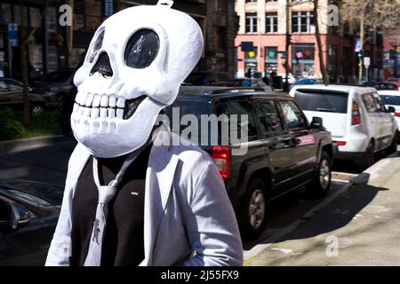 Seattle, Stati Uniti. 15th Apr 2022. Una persona che indossa una gigantesca maschera a scheletro in Pioneer Square. Foto Stock