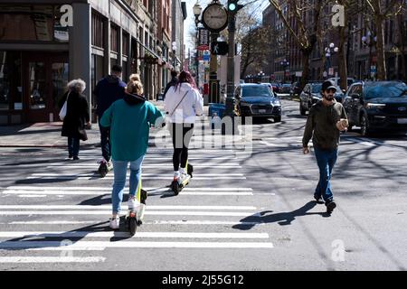 Seattle, Stati Uniti. 15th Apr 2022. Quattro persone che cavalcano scooter ev nel crosswalk in Pioneer Square. Foto Stock