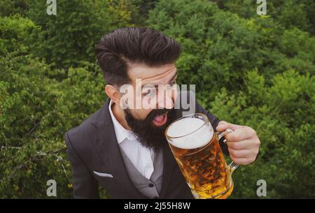 Divertente uomo pazzo con un bicchiere di birra. Degustazione e degustazione. Foto Stock