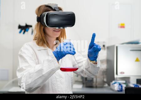 Scienziato che indossa occhiali VR, camice da laboratorio, fiasca per giocare nel cyberspazio digitale metaverse con la realtà virtuale. Tecnologia NFT di intrattenimento futuro. Foto Stock