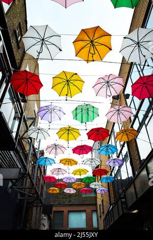 Cielo nuvoloso e un sacco di ombrelloni multicolore in cima alla strada a Dublino, Irlanda Foto Stock