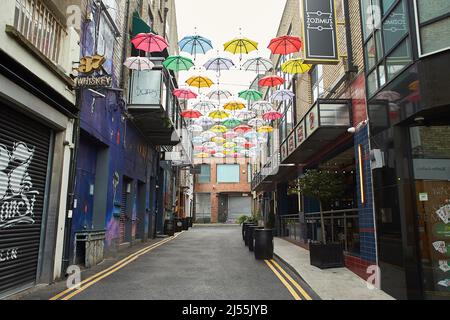 Cielo nuvoloso e un sacco di ombrelloni multicolore in cima alla strada a Dublino, Irlanda Foto Stock