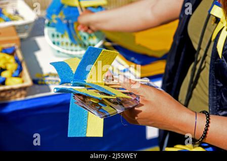 Aprile 16, 2022, Vendrell, Tarragona, Spagna: Una vista di un tavolo di vendita con i prodotti con i colori della bandiera Ucraina al Vendrell Street Market. Un gruppo di rifugiati ucraini che vivono nella città di El Vendrell dall'inizio dell'invasione russa ha svolto attività per ricevere aiuto che manderanno ai loro parenti nel loro paese. Hanno fatto bracciali, cravatte, bandiere e bambole nei colori della bandiera Ucraina (blu e giallo) e il suo prezzo è determinato dal compratore. Nella città di Vendrell ci sono circa 500 rifugiati, di cui 150 sono ragazzi e ragazze. (Credit Image: © Ra Foto Stock