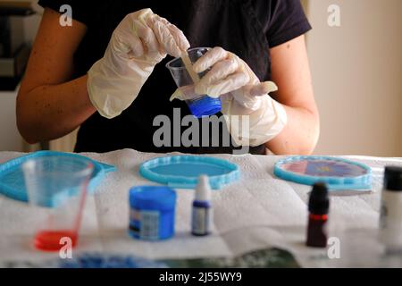 Donna che fa arti e mestieri di resina epossidica. Foto Stock