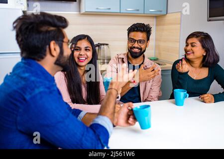 uomini e donne arabi seduti in cucina e discutere una notizia Foto Stock