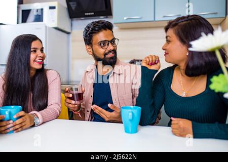 uomini e donne arabi seduti in cucina e discutere una notizia Foto Stock