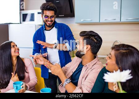 uomini e donne arabi seduti in cucina e discutere una notizia Foto Stock