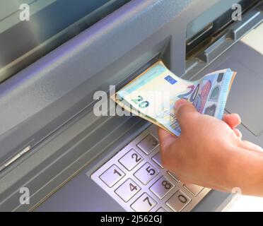 bancomat e banconote in euro e la mano di un ragazzo Foto Stock