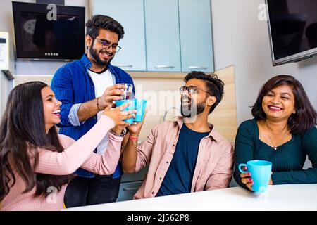 uomini e donne arabi seduti in cucina e discutere una notizia Foto Stock