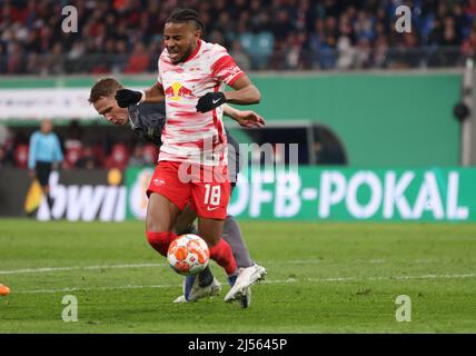 Lipsia, Germania. 20th Apr 2022. Calcio: Coppa DFB, RB Leipzig - 1. FC Union Berlin, semifinale, Red Bull Arena. Christopher Nkunku di Lipsia (fronte) è scopato da Paul Jaeckel di Berlino, la scena ha portato a un calcio di punizione. NOTA IMPORTANTE: In conformità con le norme della DFL Deutsche Fußball Liga e della DFB Deutscher Fußball-Bund, è vietato utilizzare o utilizzare fotografie scattate nello stadio e/o della partita sotto forma di immagini di sequenza e/o di serie fotografiche video-simili. Credit: Jan Woitas/dpa/Alamy Live News Foto Stock