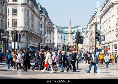 Pedoni all'incrocio diagonale di Oxford Circus, guardando verso nord su Regent Street verso All Souls Church a Langham Place, Londra, Regno Unito Foto Stock