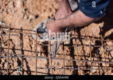 I lavoratori edili fabbricano barre di rinforzo in acciaio nel cantiere Foto Stock