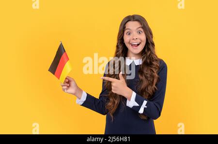 teen girl football fan. scelta direzione. stupito bambino punta dito sulla bandiera tedesca. Foto Stock