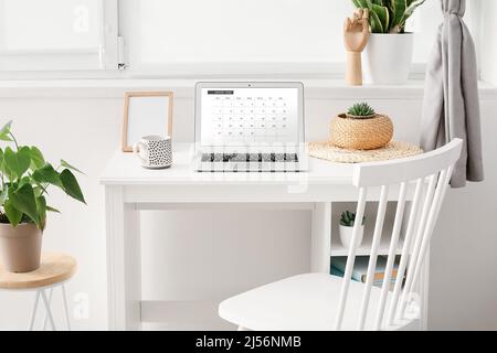 Computer portatile con applicazione calendario aperta sullo schermo a casa Foto Stock