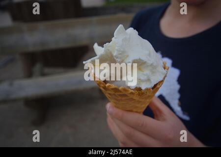 Yogurt congelato montato o gelato alla vaniglia tenuto in mano Foto Stock