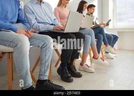 Diversi multietnici diversi uomini d'affari di razza mista in abiti casual smart che tengono computer portatili, utilizzando cellulari, carte da lettura, documenti, CV e. Foto Stock