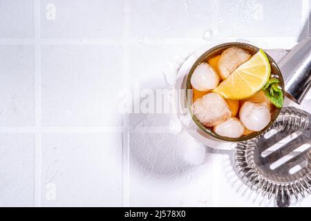 Rum, Lime e Cola Cuba cocktail Libre. Estate fredda Coca Coca Coca Coca Coca Coca Cola bevanda con succo di agrumi, cubetti di ghiaccio e foglie di menta, bianco sole piastrellato illuminato sfondo c Foto Stock