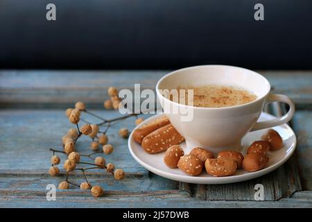 Una tazza di sahlab caldo su un rustico sfondo di legno. Foto Stock