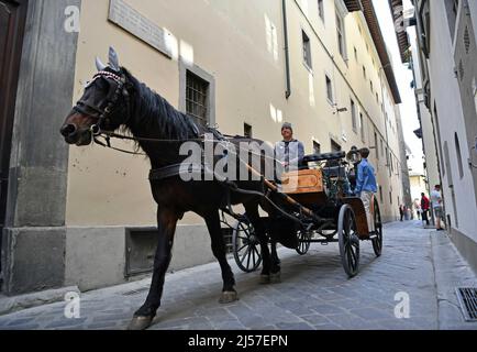 Firenze, Italia. 14th Apr 2022. Una carrozza che trasporta turisti è vista su una strada che prende il nome da Dante Alighieri a Firenze, 14 aprile 2022. Dante, poeta, celebre studioso e filosofo, nasce a Firenze nel 1265. È noto principalmente come autore della Divina Commedia, un poema epico diviso in tre libri di uguale lunghezza e considerato da critici e storici l'opera preminente in italiano. Credit: Jin Mamengni/Xinhua/Alamy Live News Foto Stock