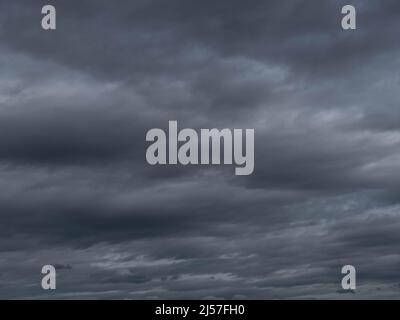 Cieli chiaramente sovrastanti. Nuvole scure, sinistre, di colore blu scuro, coprono strettamente il cielo, bloccando completamente la luce Foto Stock