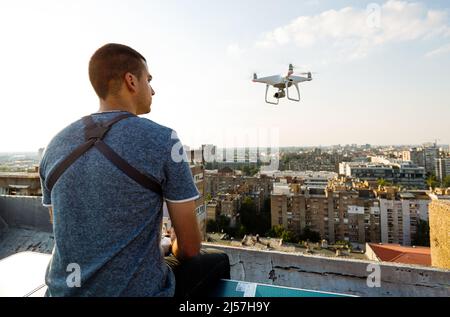 L'uomo operando un drone con controllo remoto sul tetto Foto Stock