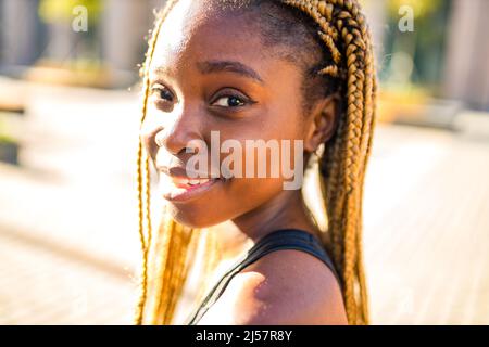 latino ispanica ragazza con lungo giallo dreadlock pigtail che si allenano all'aperto in vie ste in sity down town Foto Stock