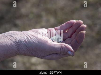 Monete russe nelle mani stropicciate di una donna anziana. Foto Stock